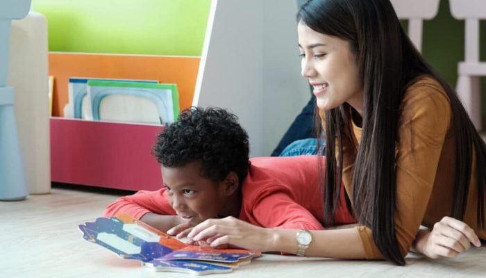 Young,Asian,Woman,Teacher,And,African,Boy,In,Kindergarten,Classroom, Young asian woman teacher and African boy in kindergarten classroom, preschool, elementary education concept